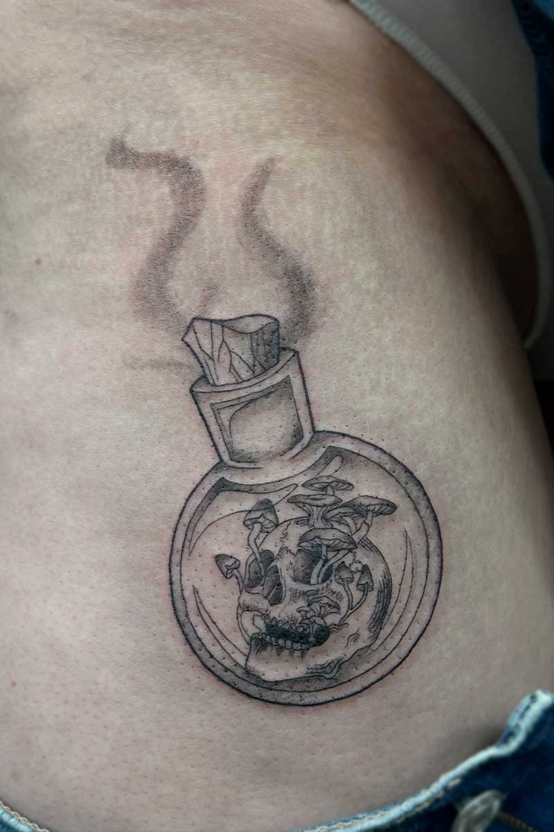 Legacy Tattoo| Illustrative tattoo of a potion bottle with a skull and mushrooms in it