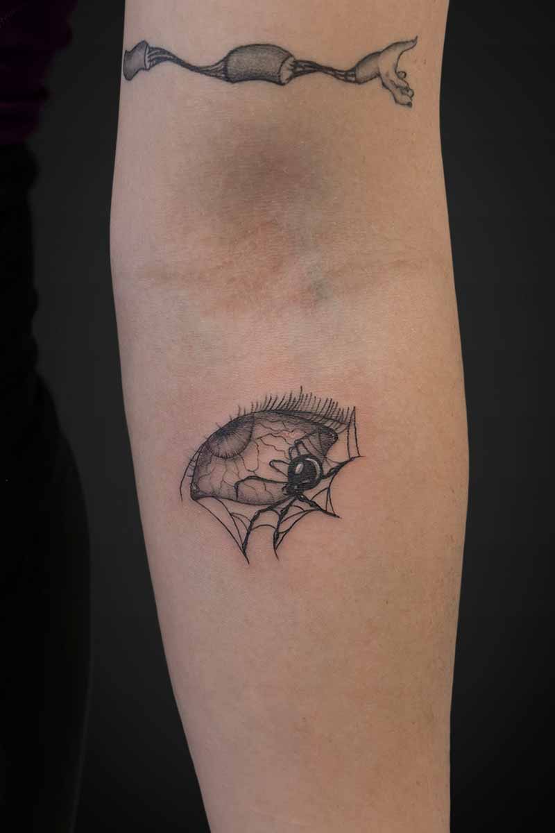 Legacy Tattoo| Illustrative tattoo of an eyeball with a spider crawling over it