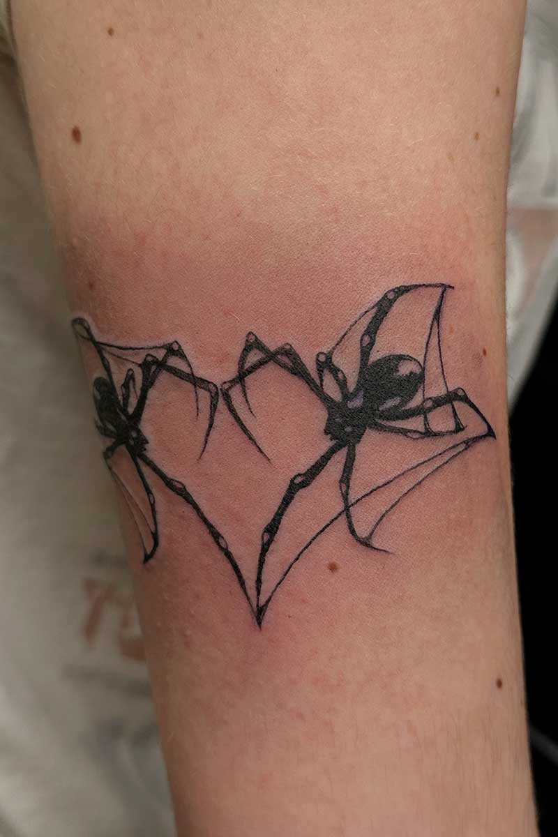 Legacy Tattoo| Blackwork tattoo of two spiders forming a heart