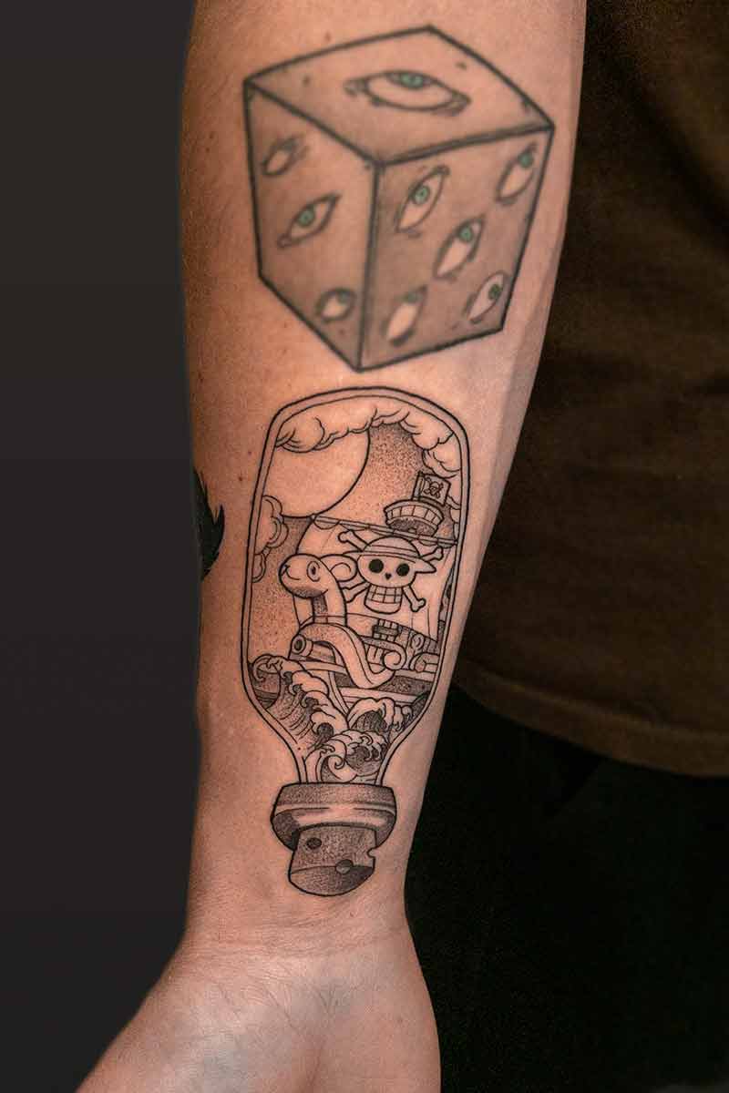 Legacy Tattoo| Black and grey tattoo of the ship from One Piece in a bottle