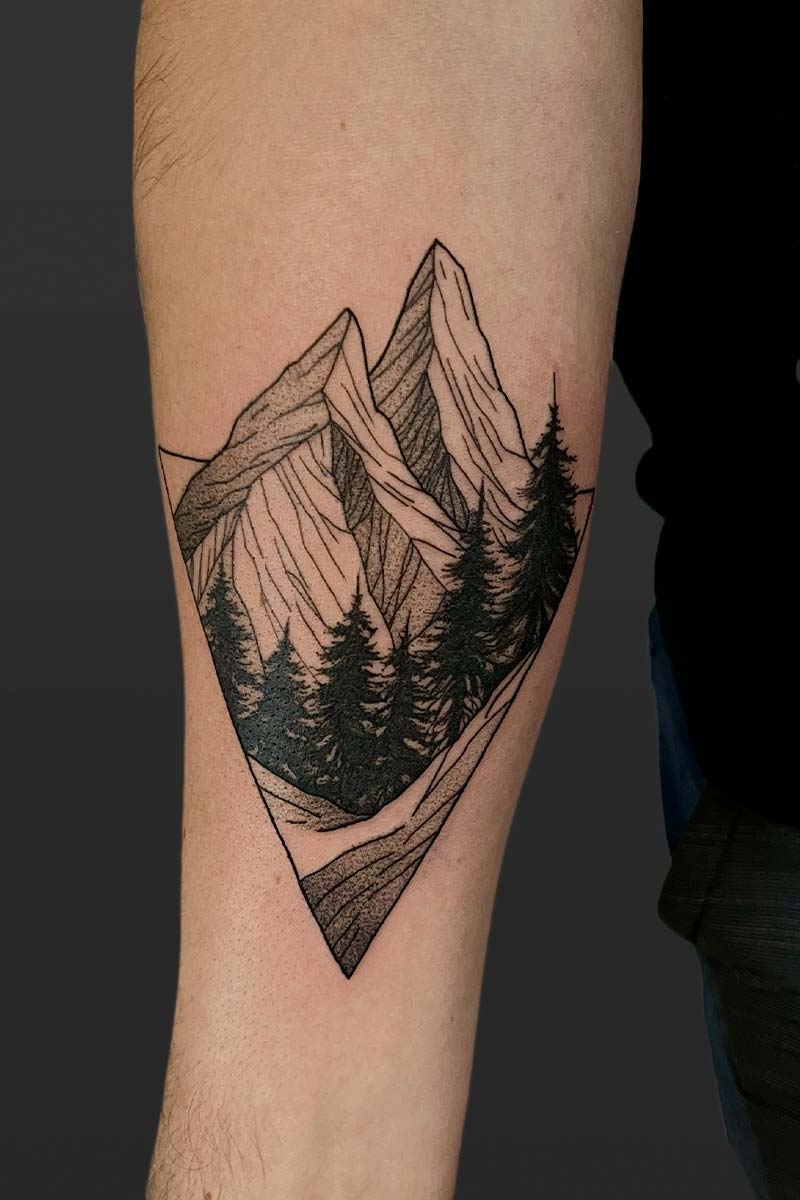 Legacy Tattoo| Black and grey tattoo of a mountain range with a forest