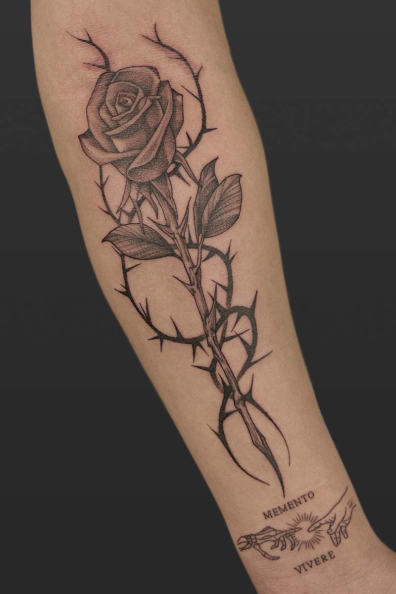 Legacy Tattoo| Black and grey tattoo of a rose and thorns