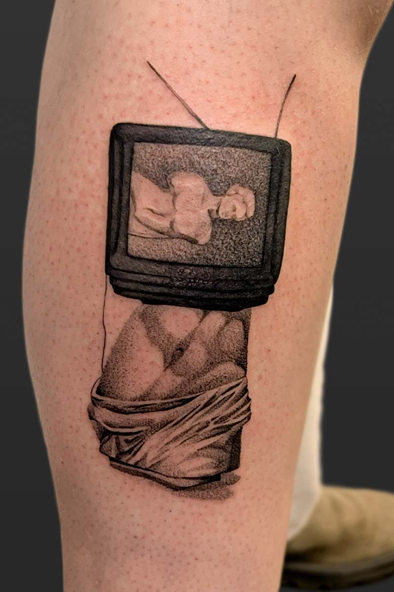 Legacy Tattoo| Black and grey, realism tattoo of the statue of Venus with a tv as her torso