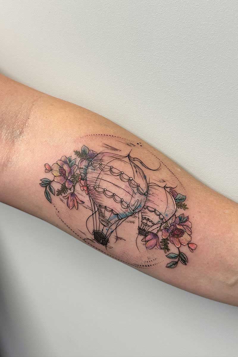 Legacy Tattoo| Fineline tattoo of colourful flowers and hot air balloons