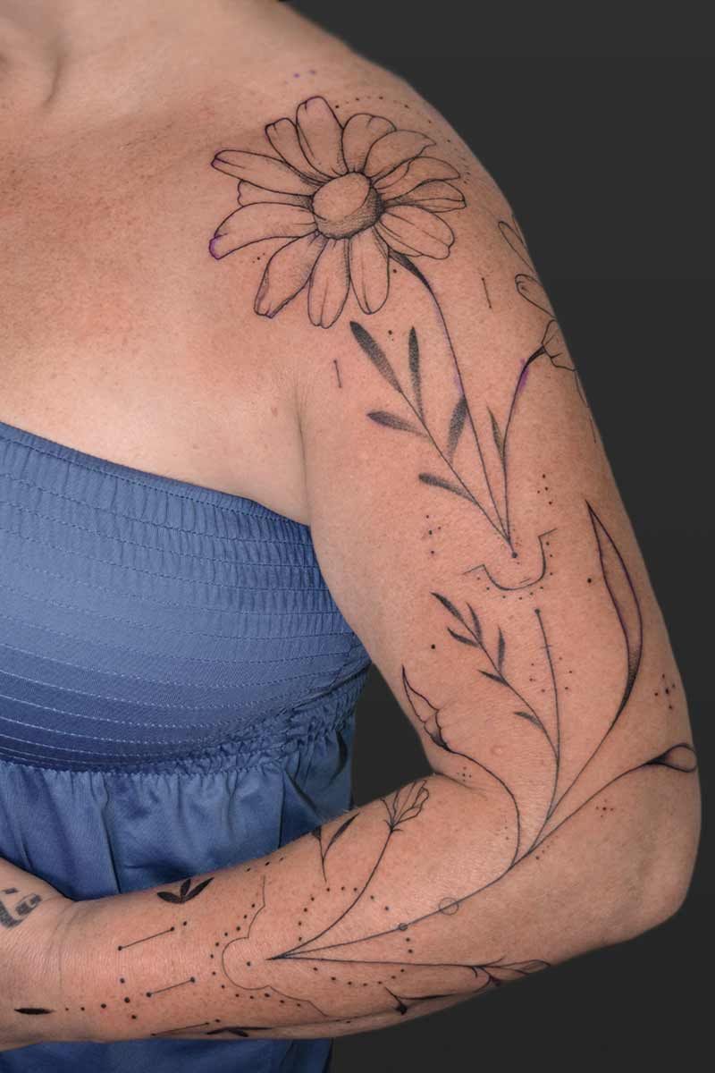 Legacy Tattoo| Fineline tattoo of two flowers and ornamentals down the client's arm