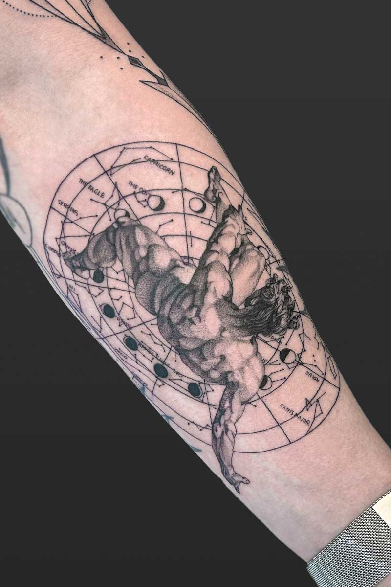 Legacy Tattoo| Black and grey, realism tattoo of Icarus falling, with an astrological map behind him