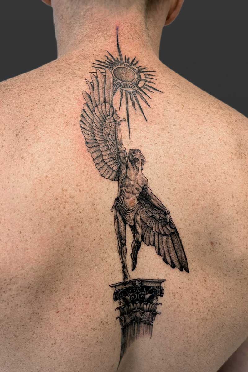 Legacy Tattoo| Black and grey, realism tattoo of Icarus, standing on a pillar and reaching towards the sun