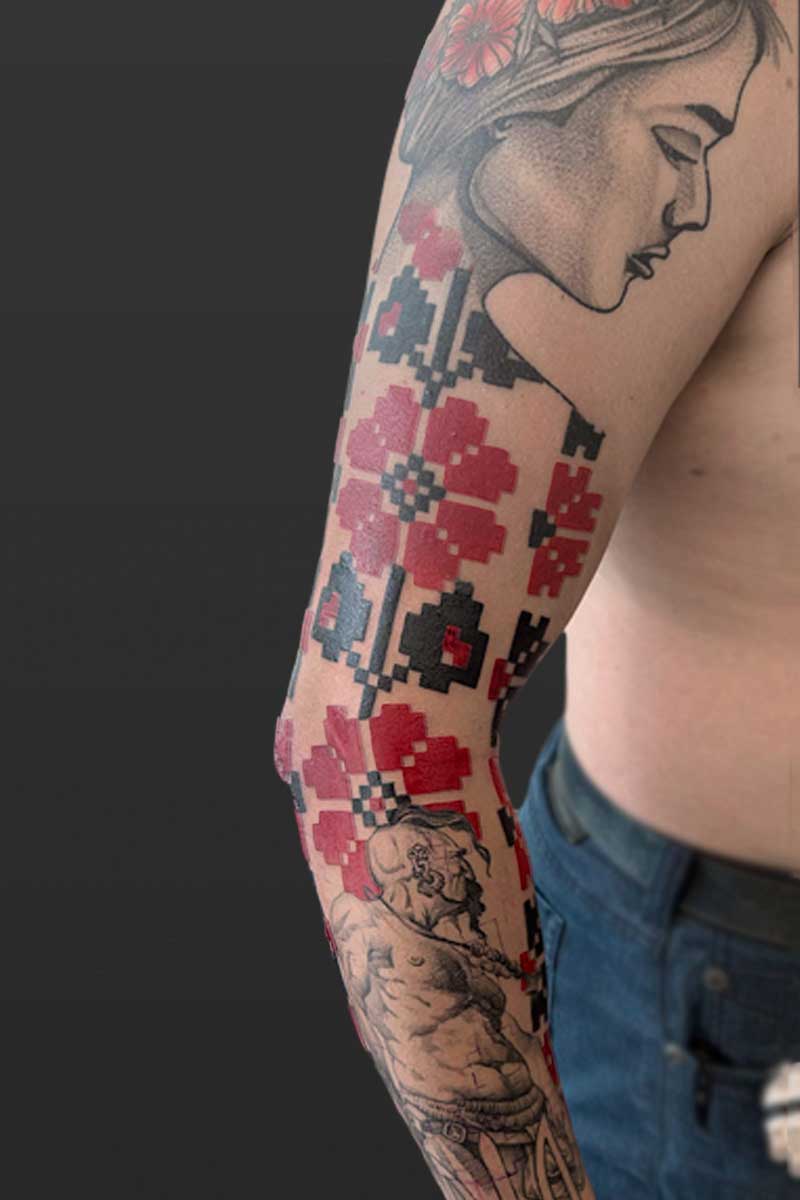 Legacy Tattoo| Black and grey tattoo of a woman, man and red and black Ukrainian, floral pattern