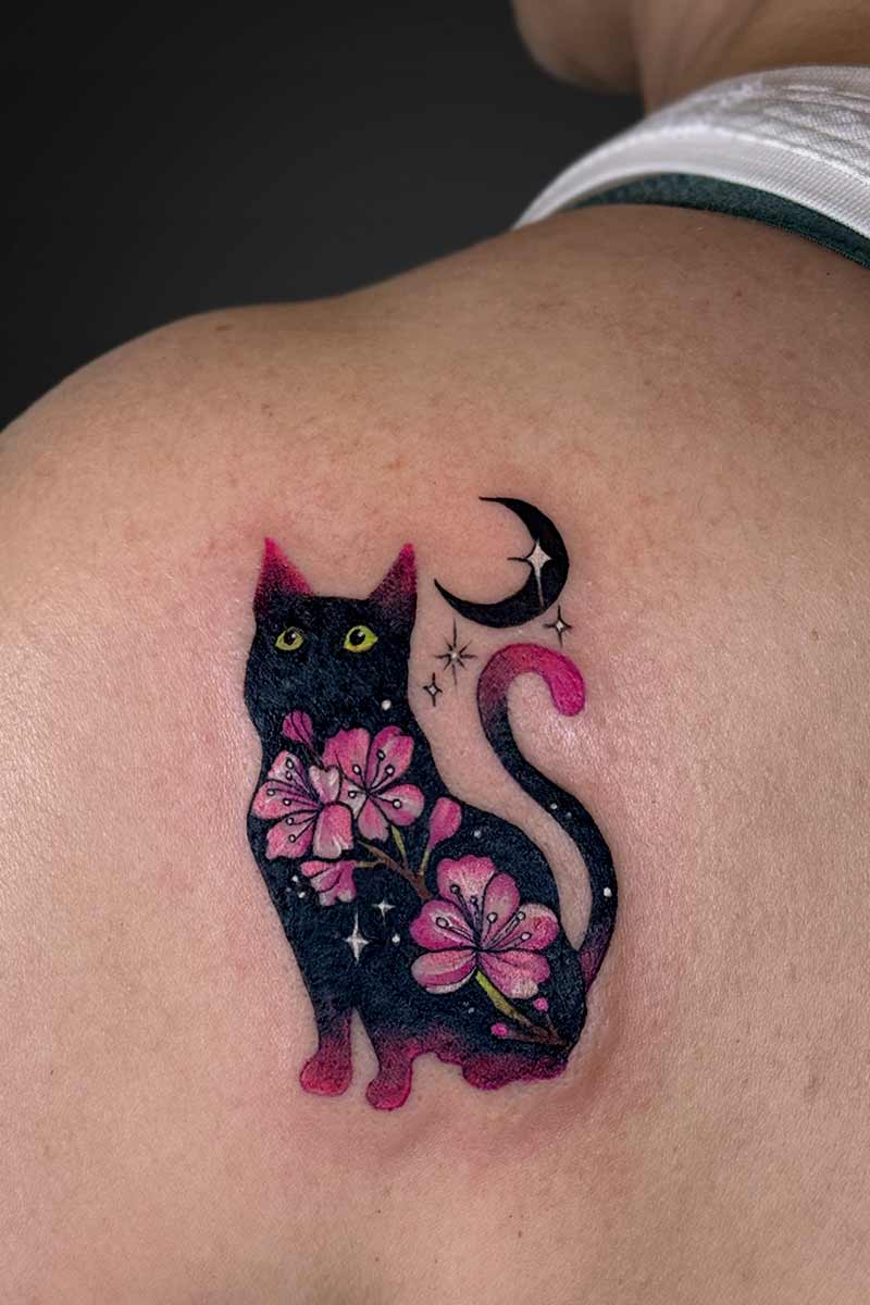 Legacy Tattoo| Colour tattoo of a black cat with pink flowers and a crescent moon with sparkles
