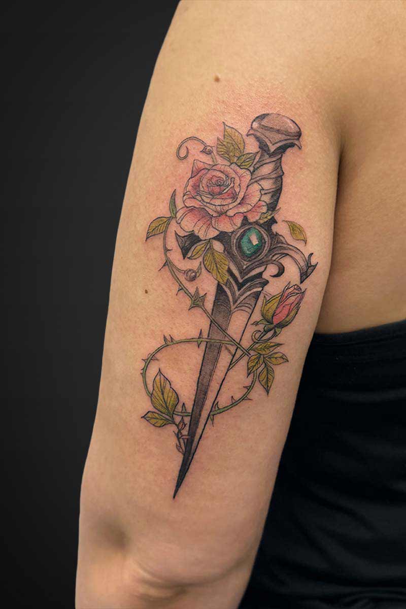 Legacy Tattoo| Floral, colour tattoo of a jewelled dagger with a rise vine
