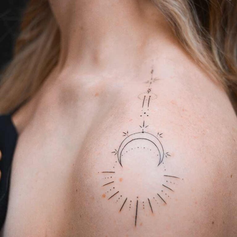 Delicate celestial tattoo on shoulder featuring a crescent moon and sun rays.